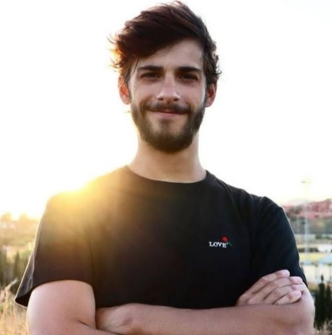 Francisco Cucullu smiling in a black shirt with a 'love' inspiring inscription